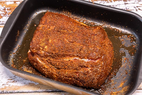 Preparation of a piece of pork roast with a rub.